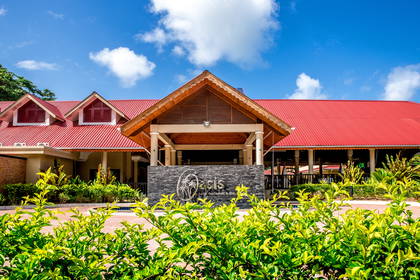 Hotel The Oasis z czerwonym dachem i szyldem.