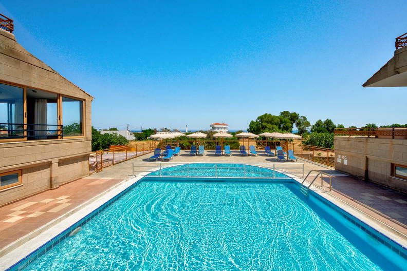 Basen hotelowy z leżakami i parasolami.