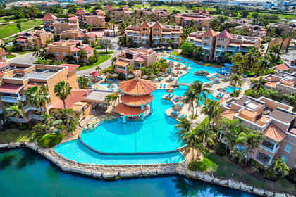 Kompleks hotelowy z basenami i palmami.