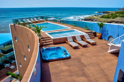 Baseny i jacuzzi na dachu budynku z widokiem na ocean (widok z góry).