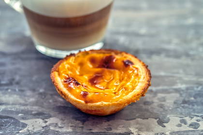 Zbliżenie na pastel de nata i latte.