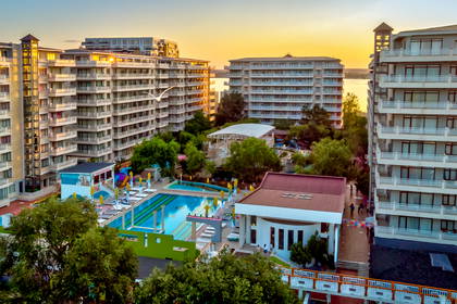 Hotel z basenem widziany z góry, w tle morze.