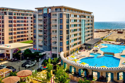 Kompleks hotelowy z basenem i plażą widziany z góry.