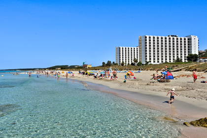 Plaża z turystami. W tle widoczne hotele.