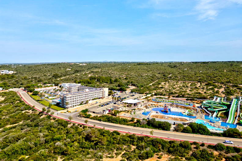 Panorama hotelu z aquaparkiem w otoczeniu zieleni.