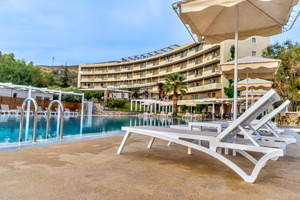 Basen z leżakami i parasolami przy hotelu.