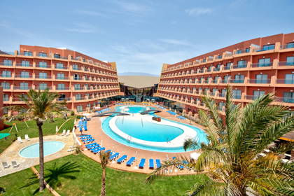 Hotel z basenem i palmami, widok z góry.