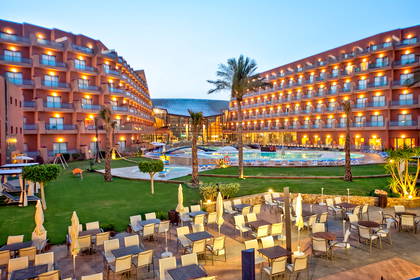 Hotel z basenem i zewnętrznym miejscem do siedzenia.
