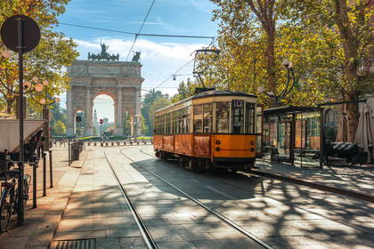 Żółty tramwaj na tle Arco della Pace w Mediolanie.