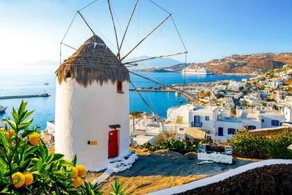 Wiatrak na tle zabudowań Mykonos, Grecja.