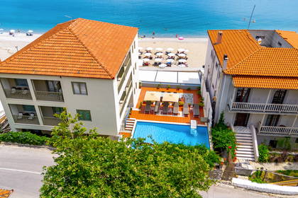 Hotel z basenem, plażą i morzem w tle, widok z góry.
