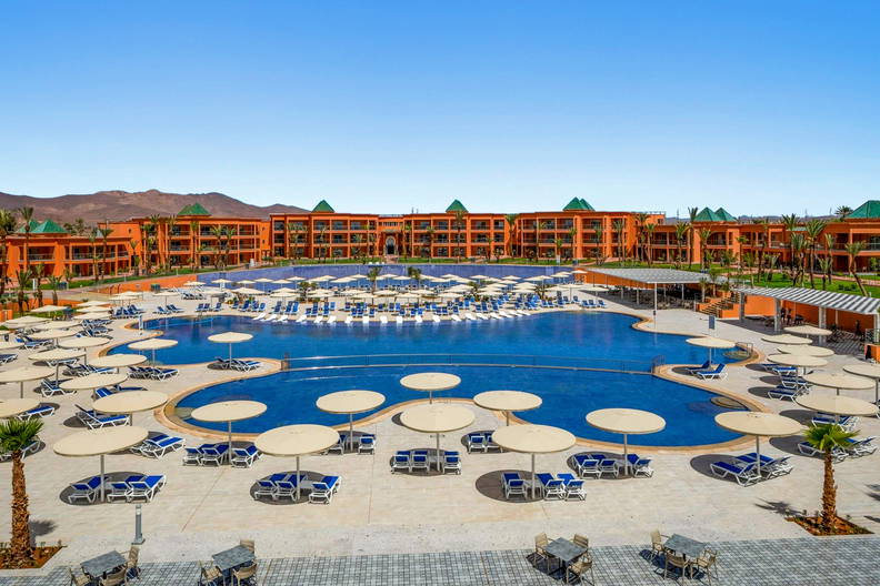 Hotel z basenem i leżakami.