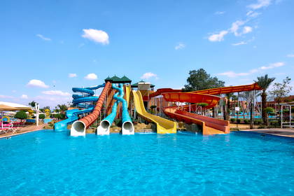Aquapark ze zjeżdżalniami i basenem w słoneczny dzień.