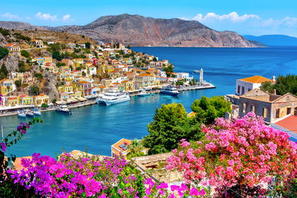 Kolorowe budynki i kwiaty w porcie Symi w Grecji.