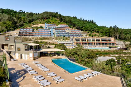 Hotel z basenem i leżakami na wzgórzu.