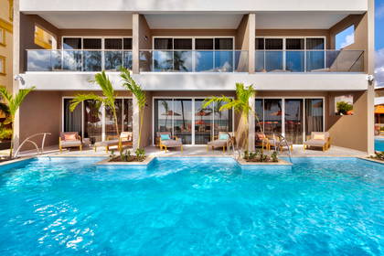 Hotel z basenem, tarasami i palmami.