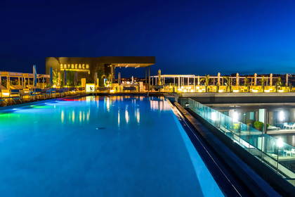 Sky Beach: nocny widok na basen na dachu budynku.