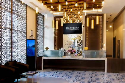 Recepcja hotelu Central Inn z ekranem i dekoracyjnym oświetleniem.