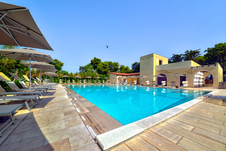 Basen hotelowy z leżakami i parasolami.