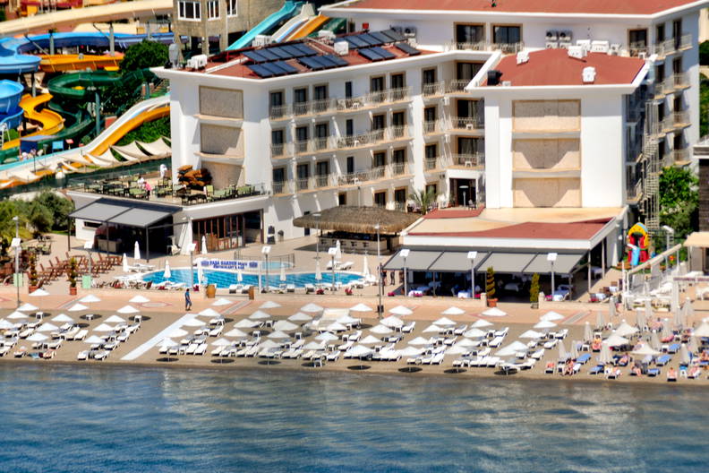 Hotel przy plaży z leżakami i parasolami.