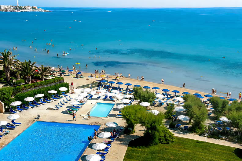 Hotel z basenami i plażą widziany z góry.