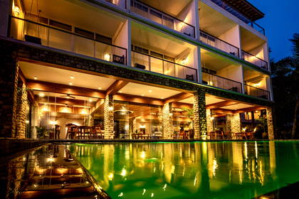Hotel widziany nocą z poziomu basenu.