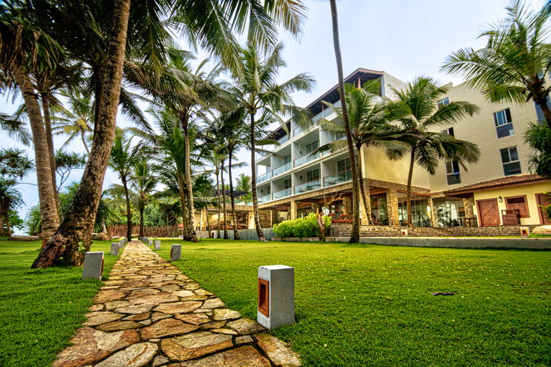 Kamienna ścieżka prowadzi do hotelu otoczonego palmami.