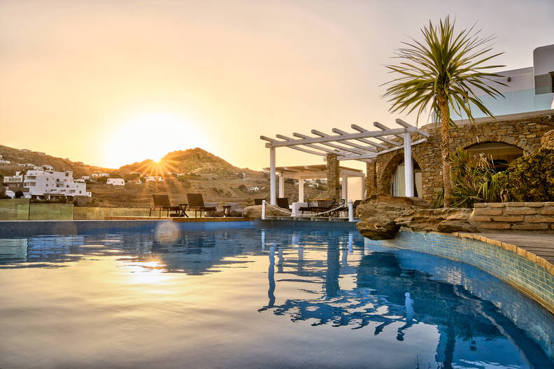Basen z widokiem na zachód słońca na Mykonos.