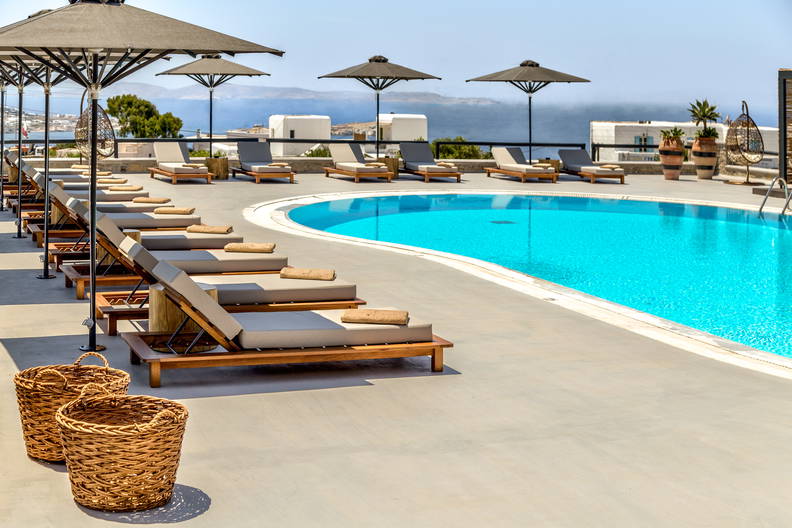 Basen z leżakami i parasolami przy hotelu.