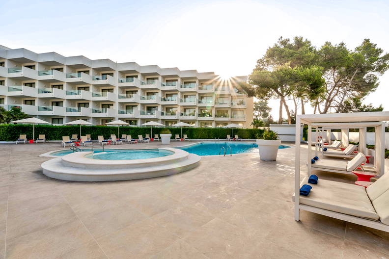 Hotel z basenem i leżakami do opalania.