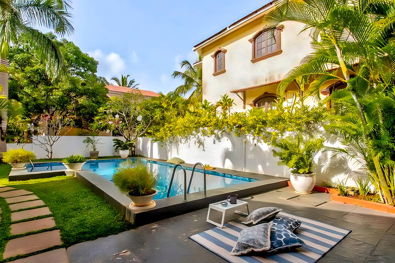 Basen otoczony tropikalną roślinnością i willami.