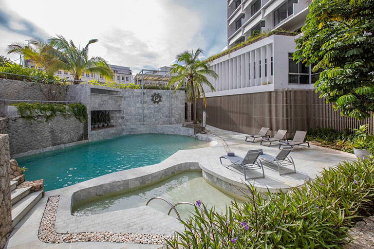 Basen w kurorcie. Wokół palmy i leżaki.