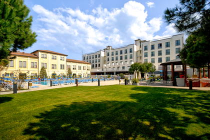 Hotel z basenem i trawnikiem.