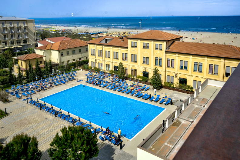 Basen w kurorcie nad morzem, widok z góry. W tle plaża.