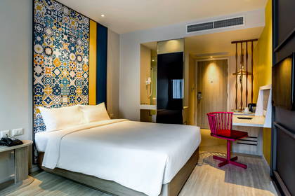 Pokój hotelowy z łóżkiem, biurkiem i krzesłami.