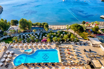 Hotel z basenem i plażą widziany z góry.