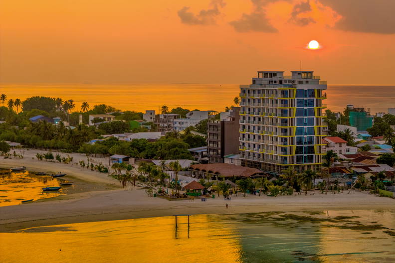 Widok na miasto i plażę o zachodzie słońca.