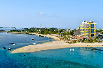 Tropikalna wyspa z lotu ptaka. Widoczne turkusowa woda, plaże i hotel.