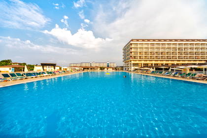 Basen z leżakami przy hotelu.
