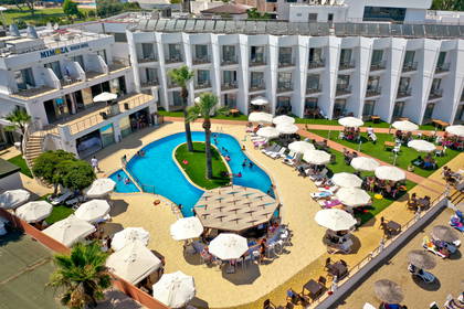 Widok z góry na basen, bar i plażę w hotelowym kurorcie.