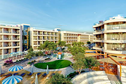 Hotel z basenem i leżakami widziany z góry.