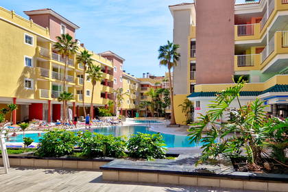 Kompleks hotelowy z basenem i palmami.