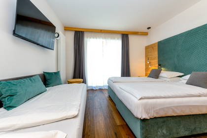 Pokój hotelowy z dwoma łóżkami i telewizorem.