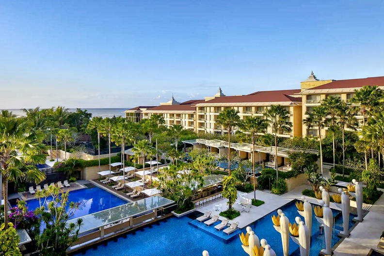 Luksusowy hotel z basenami i palmami.