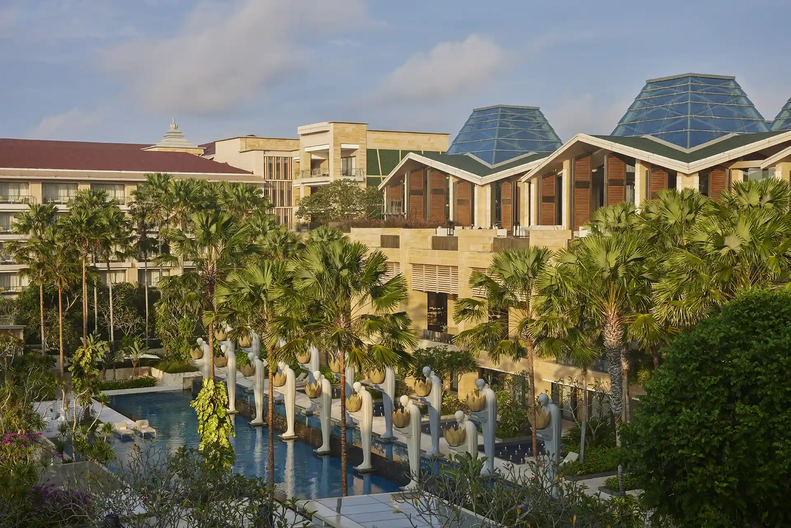 Luksusowy hotel z basenem i palmami.