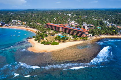 Hotel nad oceanem sfotografowany z lotu ptaka. W tle plaża i las.
