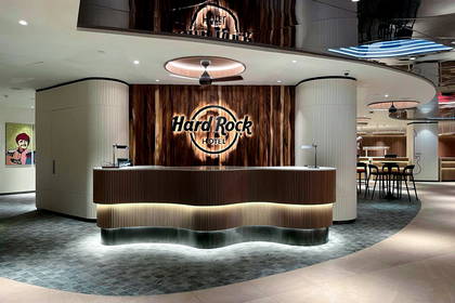 Recepcja w Hard Rock Hotelu z logo na drewnianej ścianie.