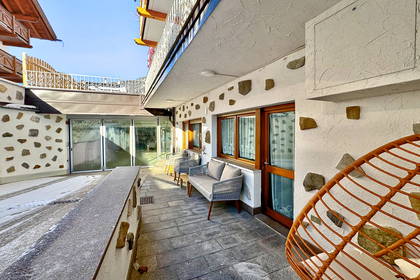 Patio z meblami ogrodowymi i wiklinowym fotelem.
