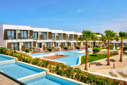 Luksusowy resort z basenami, palmami i białymi budynkami.