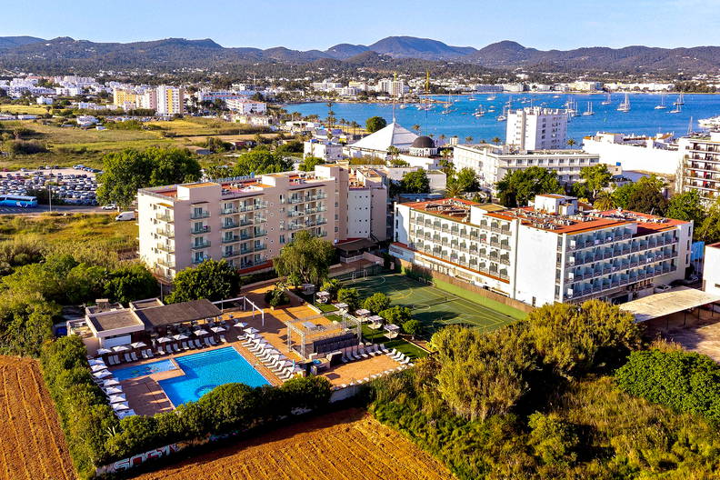 Kompleks hotelowy z basenem i kortem tenisowym, widok z lotu ptaka. W tle morze.